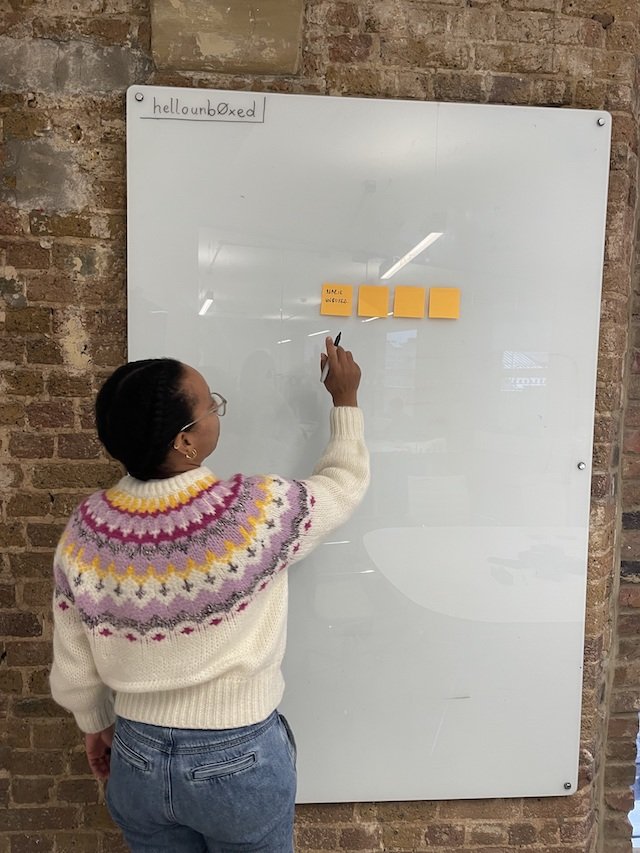 Marie Ferreira pointing at post it notes on a white board