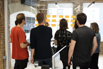 People looking at a wall of postit notes
